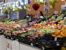 marchande envahie par les couleurs de ses fruits